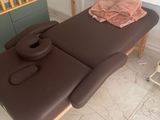 une table de massage recouverte d'une serviette, dans une pièce