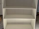 a white bookcase that is in a garage