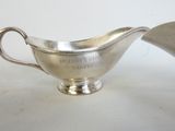 une saucière ancienne en argent, munie d'une poignée et d'une cuillère