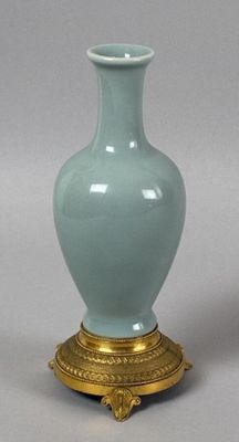 a blue vase sitting on top of a gold stand