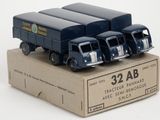 quatre camions miniatures posés dans une boîte sur une surface blanche