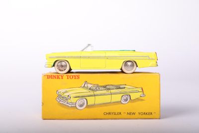 yellow toy car sitting on top of a yellow box on a white surface