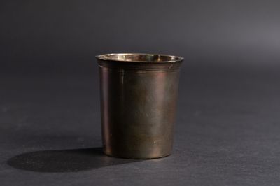 un gros plan d'une tasse en métal posée sur une surface noire