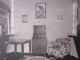 a black and white photo of a living room with a chair and a table