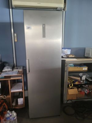 an image of a refrigerator in a room with a lot of clutter on the floor
