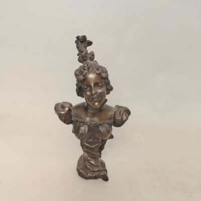 une statue en bronze représentant une femme avec un oiseau sur la tête