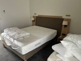 two beds in the room with white sheets on them