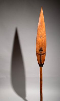 an image of a wooden paddle with a shadow of a person on it