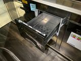 an oven that has a drawer with donuts inside of it