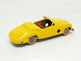 a yellow toy car that is on a white surface