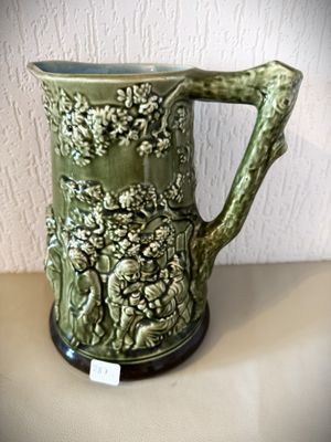 une grande tasse verte avec une anse, posée sur une table