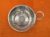 a silver object on a orange cloth with a ring on it