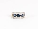 un gros plan d'une bague en or blanc sertie de saphirs bleus et de diamants