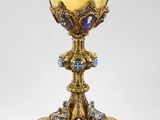 un calice en or richement décoré, orné d'une croix bleue et blanche