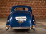 a blue car parked in front of a brick wall