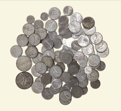 une pile de pièces d'argent posée sur une surface blanche