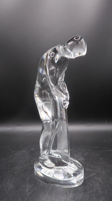 une image représentant une figurine en verre représentant un homme tenant un club de golf