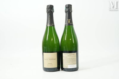 deux bouteilles de vin posées l'une à côté de l'autre sur une surface blanche