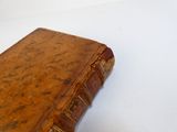 un vieux livre posé sur une surface blanche, sur fond blanc