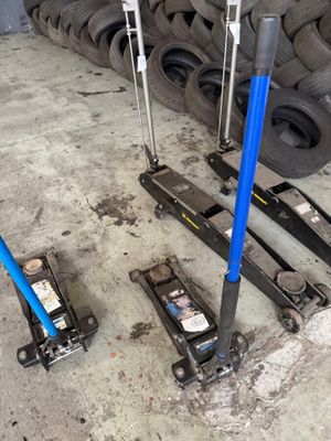 two jacks that are sitting on the ground next to a pile of tires