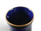a close up of a blue cup on a white surface