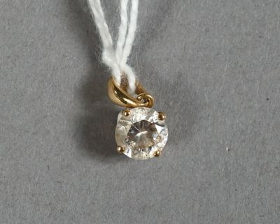 un gros plan d'un pendentif en diamant suspendu à un cordon, posé sur une surface grise