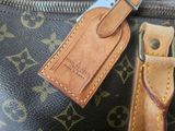 a close up of a louis vuitton bag with a name tag