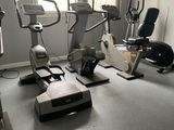 a gym room with several stationary exercise bikes in it