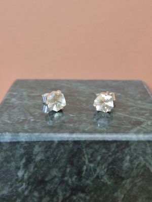 une paire de boucles d'oreilles en diamant posée sur une table en marbre