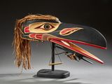 une image représentant un masque en bois orné d'une tête d'oiseau
