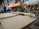 a machine that is cutting a piece of wood in a factory