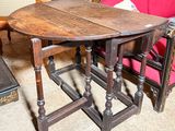 une table avec un plateau en bois et un canapé rouge en arrière-plan