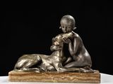 statue en bronze représentant un garçon et un chien, posée sur un socle en marbre