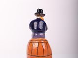 a figurine of a man sitting on top of a barrel