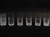 six shot glasses are lined up in a row on a black background