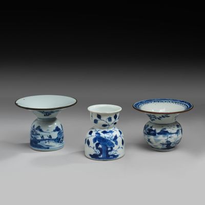 three blue and white vases and a bowl on a table