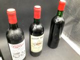 three bottles of wine sitting on a counter next to each other