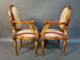 a pair of chairs with a striped upholstered back and arms