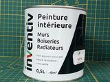 un pot de peinture posé sur un tapis de découpe