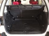 the back of a white car with its trunk open and seats down