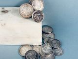 un bloc de marbre sur lequel est posé un tas de pièces de monnaie