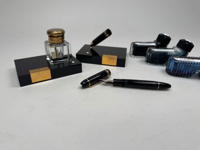 plusieurs stylos et encriers posés sur une table blanche