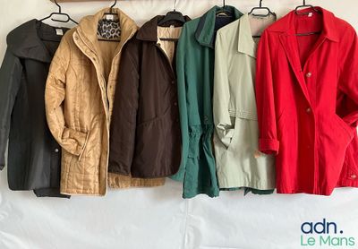 many coats hanging on a rack on a wall