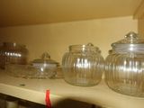 de nombreux bocaux en verre sur une étagère de la cuisine