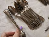a person that is holding a spoon and spoons on a table