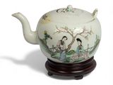 a white teapot with a painting on it on a stand