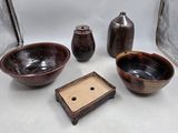 trois bols et deux vases posés sur une table