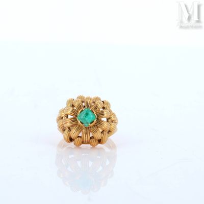 a close up of a gold ring with a green stone