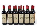 six bottles of wine lined up in a row on a white surface