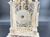 a white clock that is sitting on a table